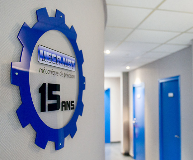 Panneau MECA-MAT 15 ans en forme d'engrenage, couloir avec portes bleues à Bourges dans le Cher