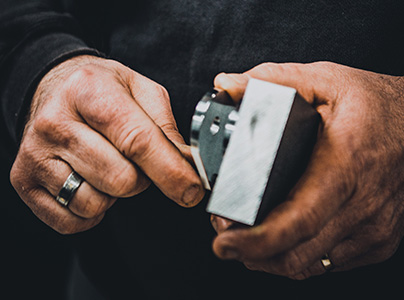 Mains masculines tenant et inspectant une pièce métallique usinée à Bourges dans le Cher 18