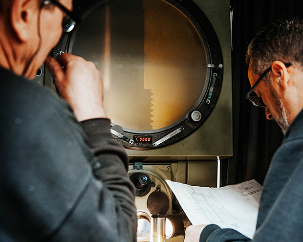 Deux hommes examinent des mesures sur un projecteur de profil industriel à Bourges dans le Cher 18